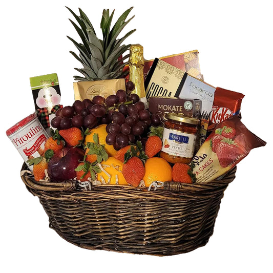 Wicker basket with fruit, sparkling cider and treats
